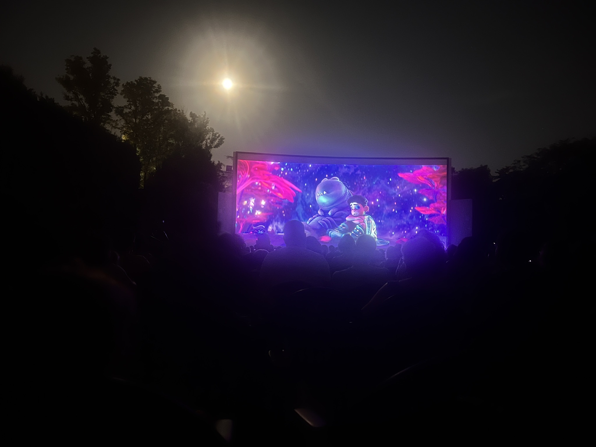 Audience watching Pixar’s Elio at open‑air cinema; low‑light phone photo